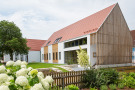 Das Begegnungs- und Pfarrgemeindezentrum in Pfaffenhausen  in schlichter Bauform und steilem Satteldach ohne Dachüberstand besticht durch seine  „schwäbische Architektur“.