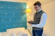 Botschafter Josef hakt eine Checkliste in einem Zimmer ab.