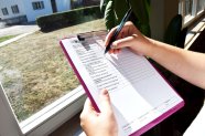 Eine Person hakt Punkte auf einer Liste ab