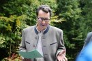 Eine Person mit Brille und einem Zettel in der Hand. 