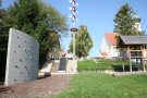 Teilbereich des Spielplatzes mit Kletterwand, Rutsche, Kletterturm und Seilgerüst. 