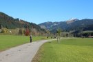 Ein Jogger auf einem ausgebauten Wirtschaftsweg, im Hintergrund die Berge.