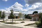 Dorfgemeinschaftshaus in Mönstetten mit weißer Außenfassade, rechts ein kleines Backhaus.