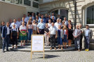 Gruppenbild mit zahlreichen Personen auf einer Treppe stehend.