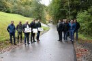 Eine Gruppe von Menschen steht an einem Weg.   