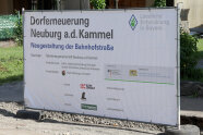 Ein Baustelleninformationsschild in Größe eines Bauzaunes. 