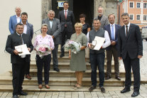 Ehrengäste und Betroffene stellen sich zum Gruppenfoto vor das Nördlinger Rathaus.