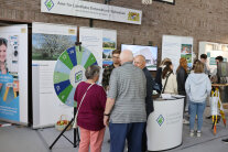 Besucher und Standbetreuer am Messestand des Amtes.