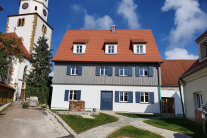 Ansicht auf das sanierte Gebäude im Umfeld der Birkhausener Kirche.