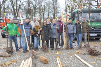 Gruppenbild von Mitarbeiterinnen und Mitarbeitern, die Bäume in Empfang nehmen.