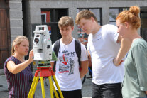 Mitarbeiterinnen und Schüler an einem Vermessungsgerät.