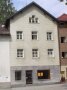 Die Fassade des dreistöckige Wohnhaus in seiner alten grauen Erscheinung vor der Sarnierung ist zu erkennen.