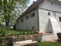 Eine gemütliche Holzbank ziert die Rückansicht des Mühlengebäudes und lädt zum Verweilen ein.