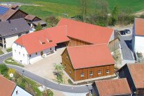Eine Luftaufnahme zeigt den sanierten Dreiseithof neben der Dorfkirche.