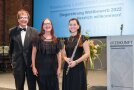 Eine Frau mit Querflöte und zwei Sänger